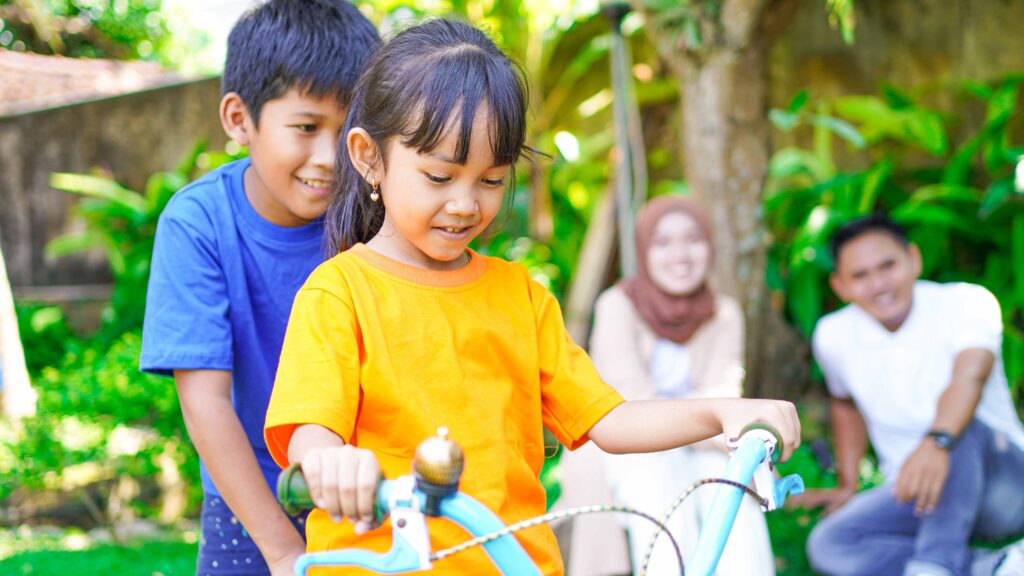 happy asian family playing bike together in the park