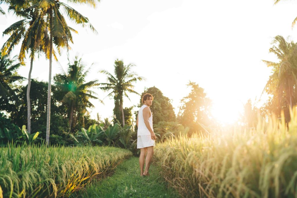 Happy man walking in tropical rice plantation fields