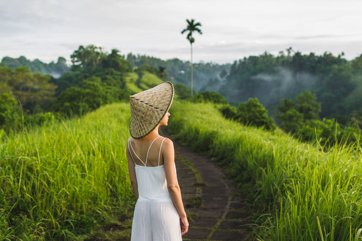 Турист, наблюдающий за знаменитыми рисовыми полями Бали, погруженный в красоту и спокойствие пейзажа.