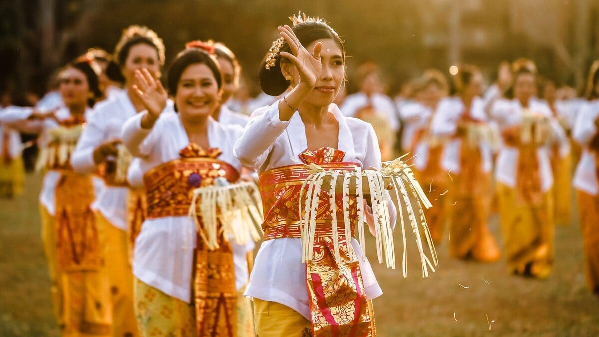 Balinese women dressed in traditional attire, gathering around a temple altar for a religious ceremony