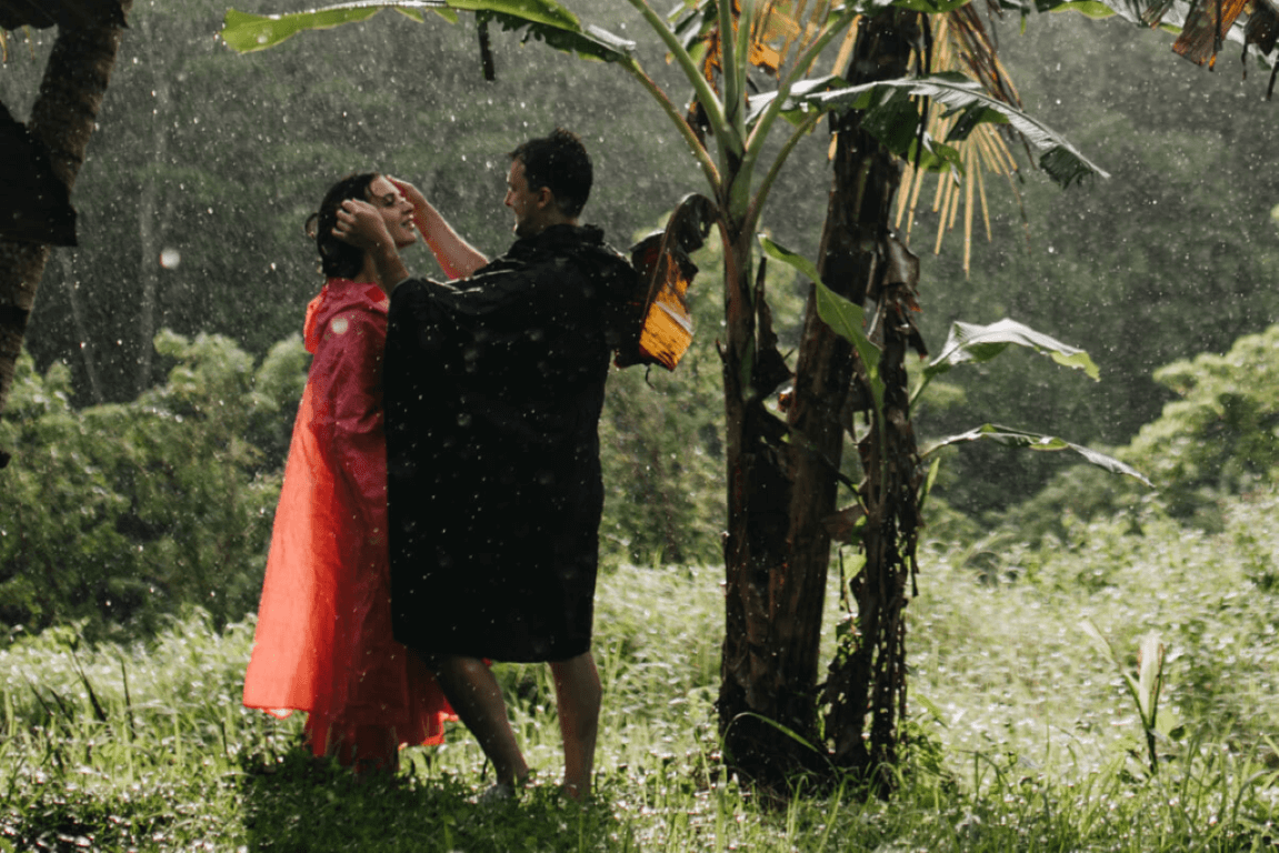 Tourists enjoying a rain in Balis wet season at a rice field