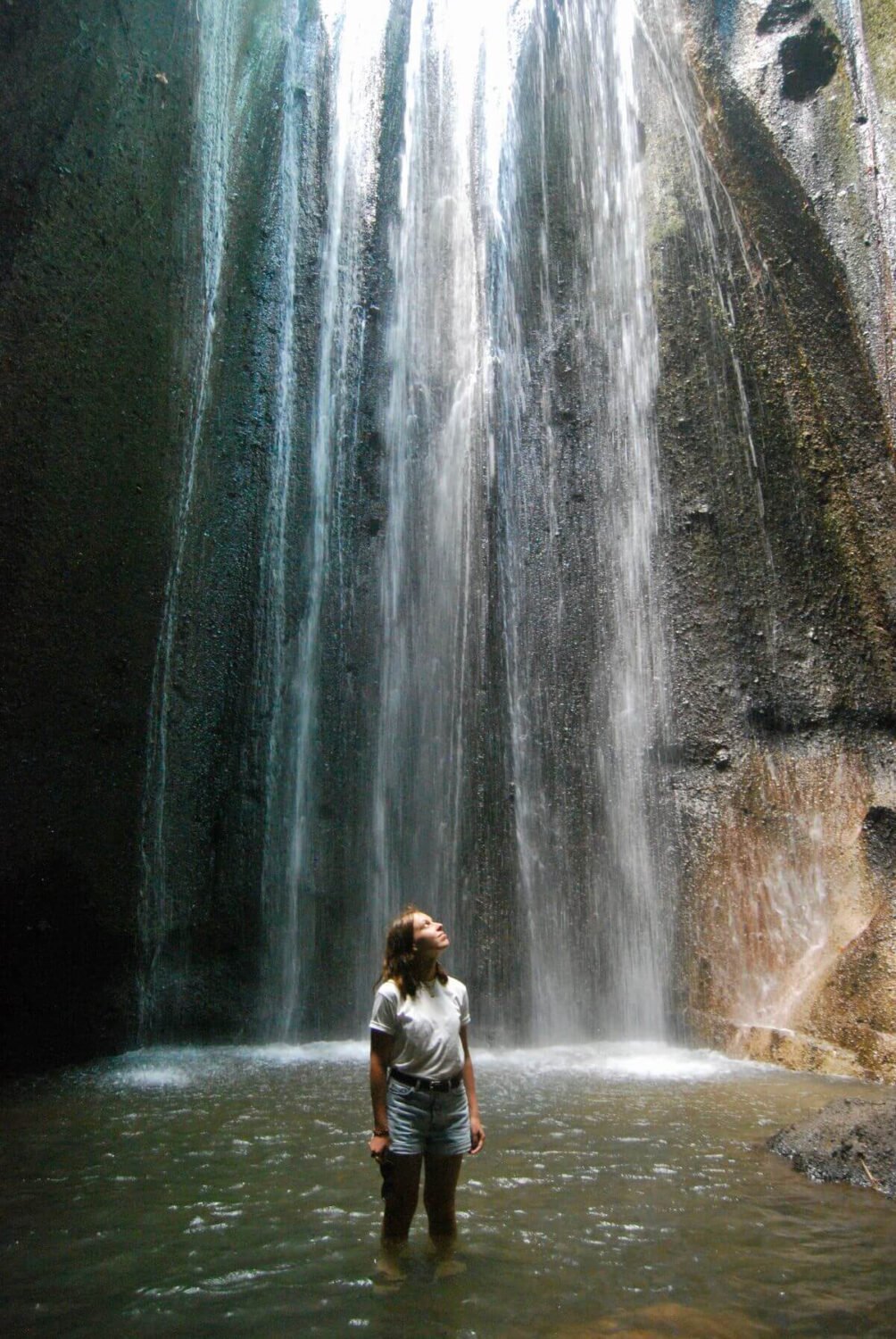 Tourist exploring Tukad Cepung Waterfall in Bali