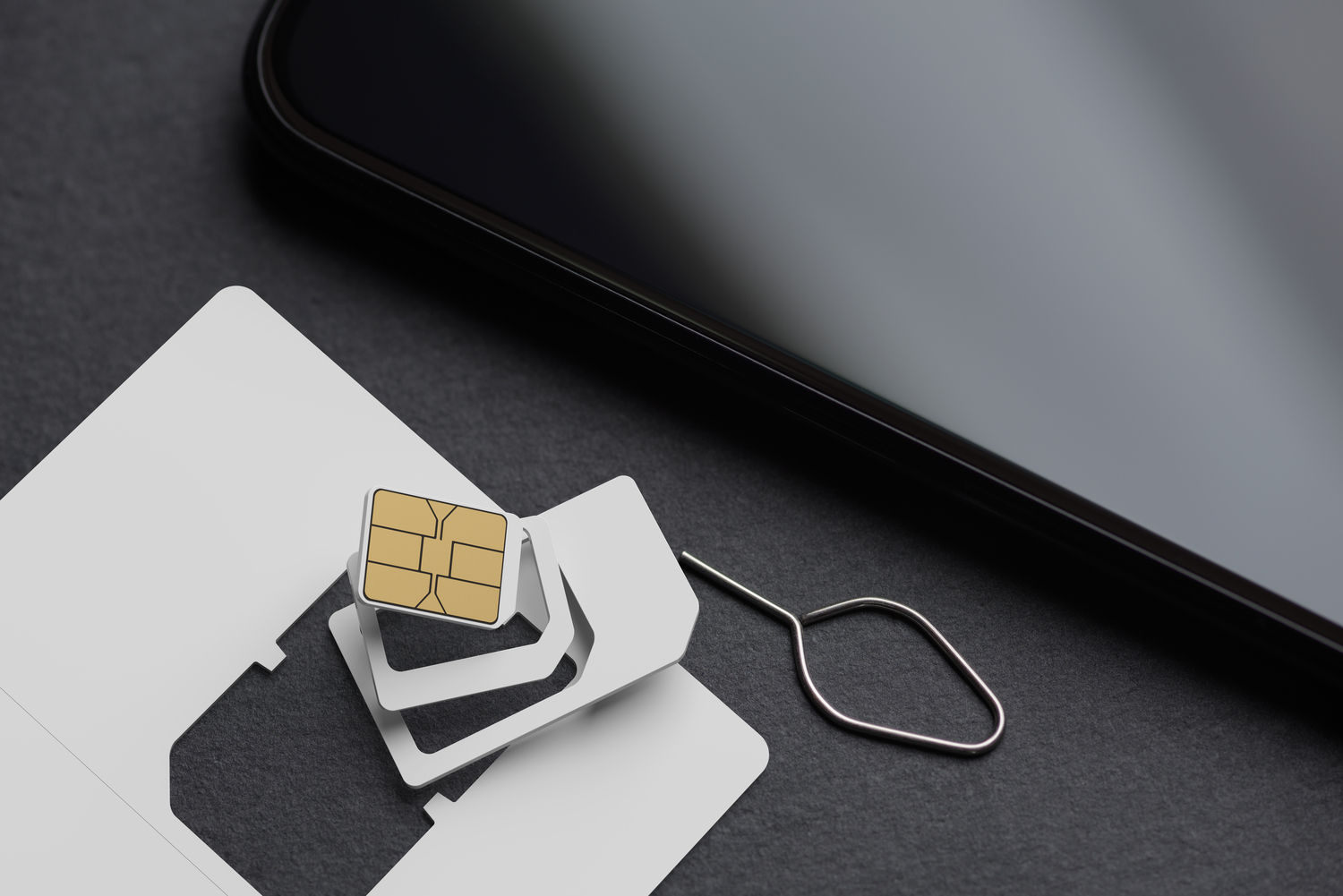 Blank white SIM card with smartphone on black slate. 3D rendering and photo
