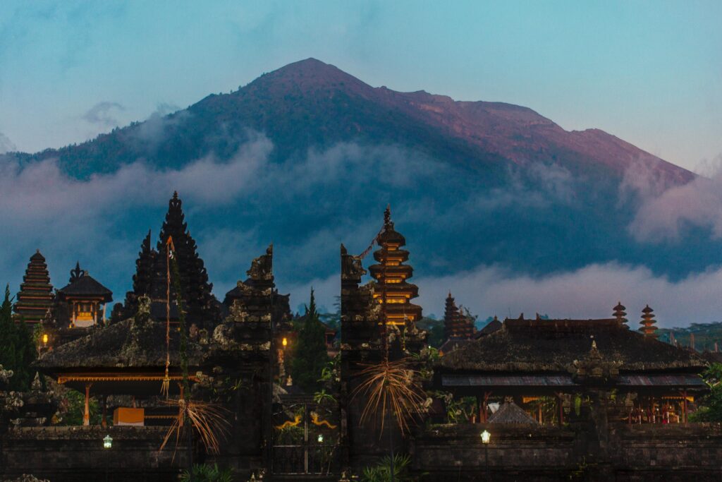 Balinese sacred mountain Agung colored in pink by sunset light Main Bali temple Pura Besakih at the foot of the volcano Agung