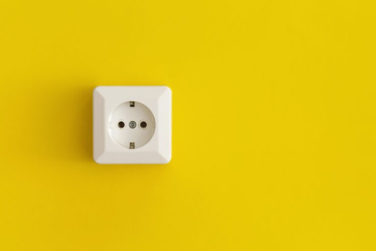 White plastic power socket on a yellow background