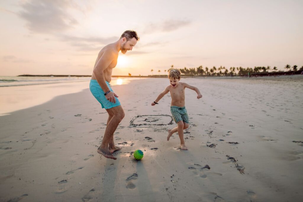 father with his son plaing football on the beach 2022 12 22 20 23 21 utc 1 1