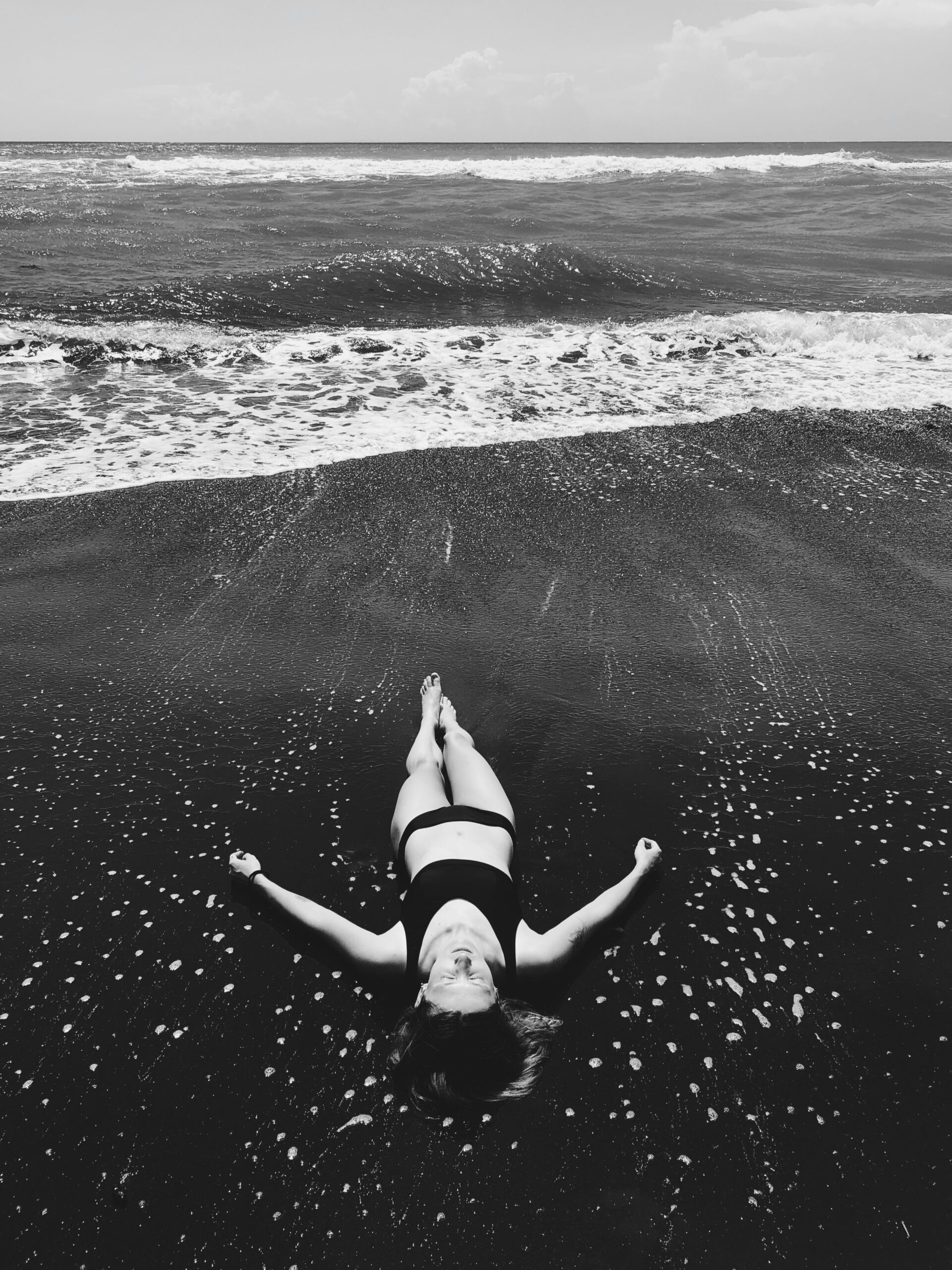 a girl laying down on the beach at Cemagi Beach