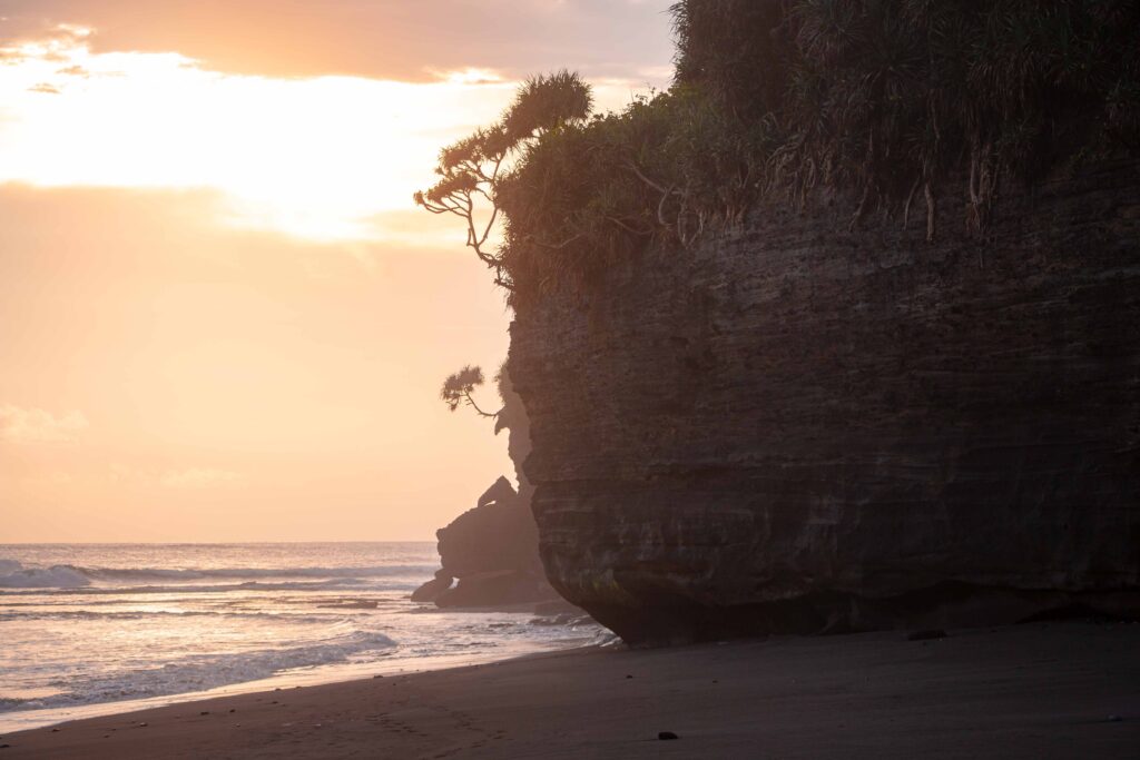 Mesmerizing view of a beach with a huge cliff at sunset in Bali, Indonesia