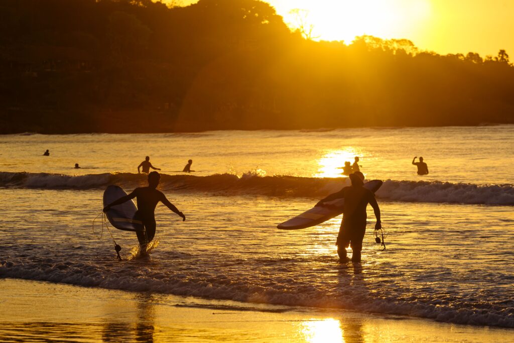 Surfers at sunset on the beach, Bali, Indonesia