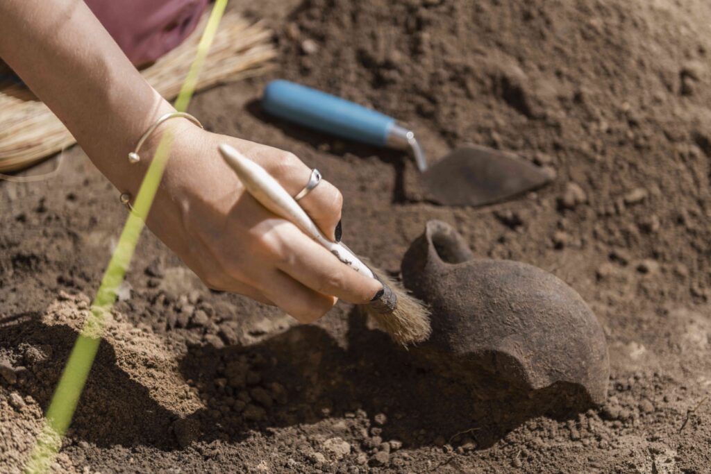 Archaeologist Recovering Ancient Pottery Object