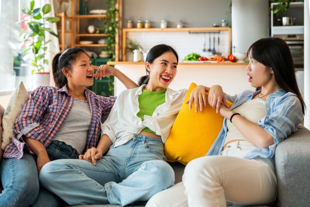 Happy beautiful chinese women friends bonding at home