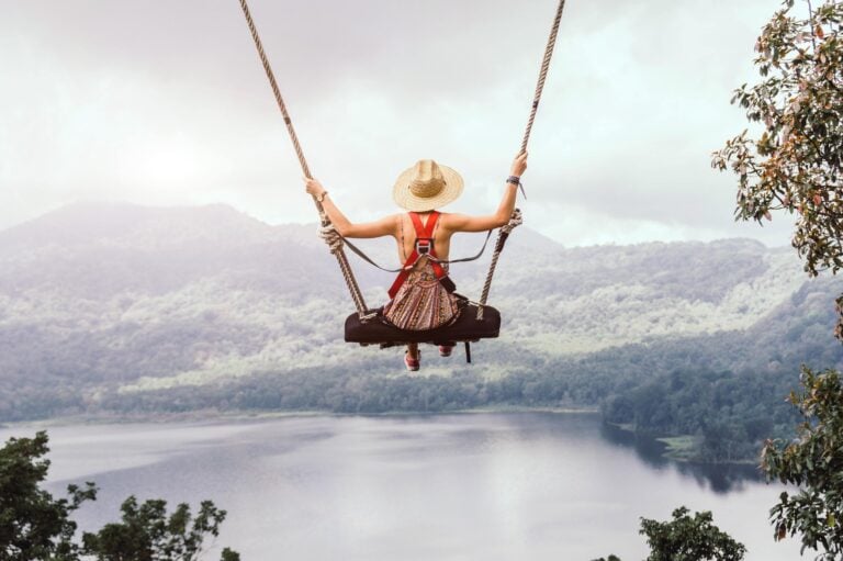 beautiful girl enjoying freedom on swing in bali