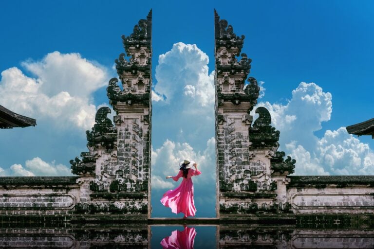 Female with a pink dress standing at Temple gates at Lempuyang Luhur temple in Bali