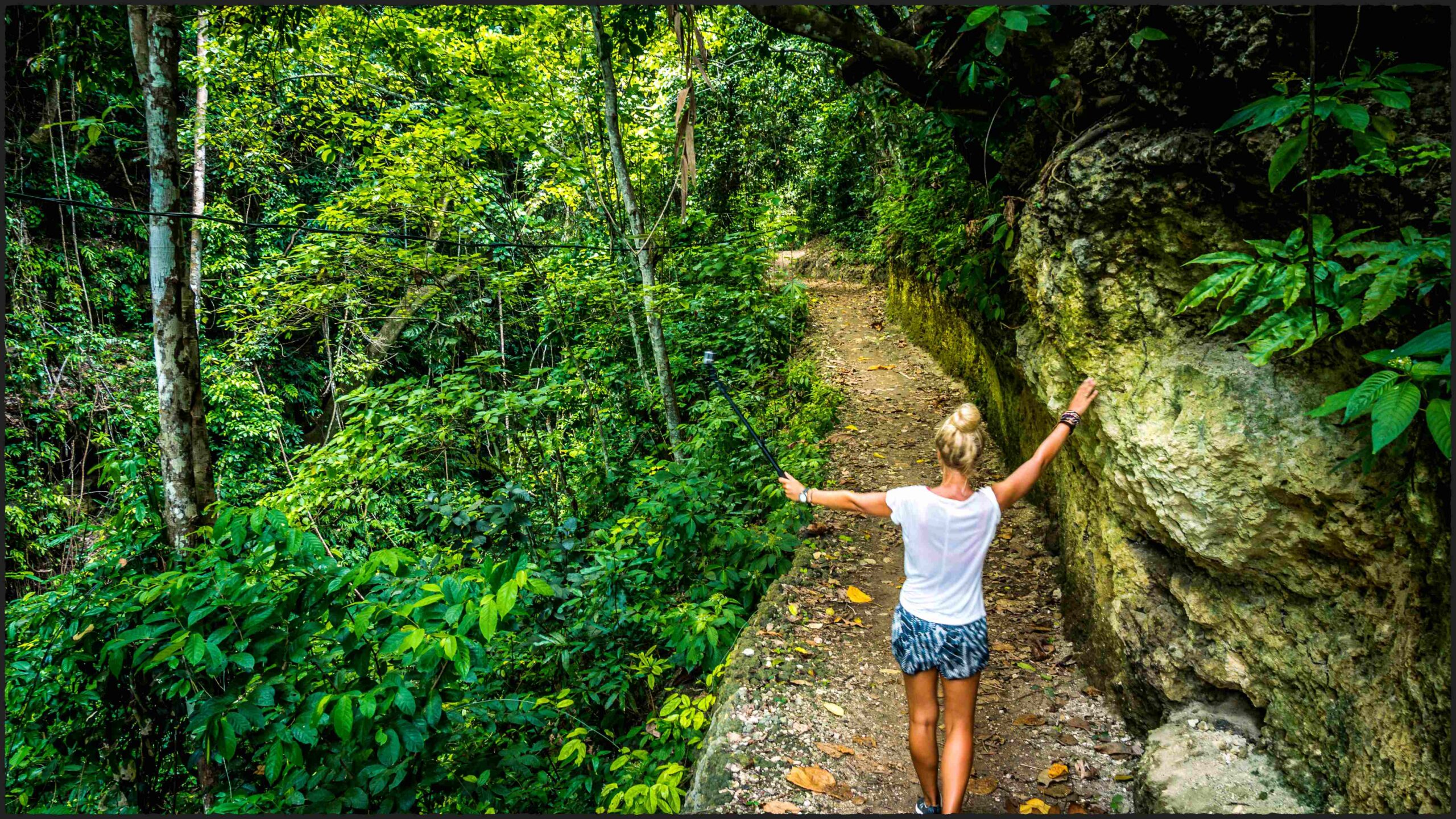 Girl on the path making selfy leading fromTembeling pool, Nusa Penida Bali Indonesia