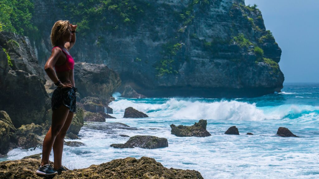 Girl standing on Tembeling Beach with view of coastline at Nusa Penida island, Bali Indonesia