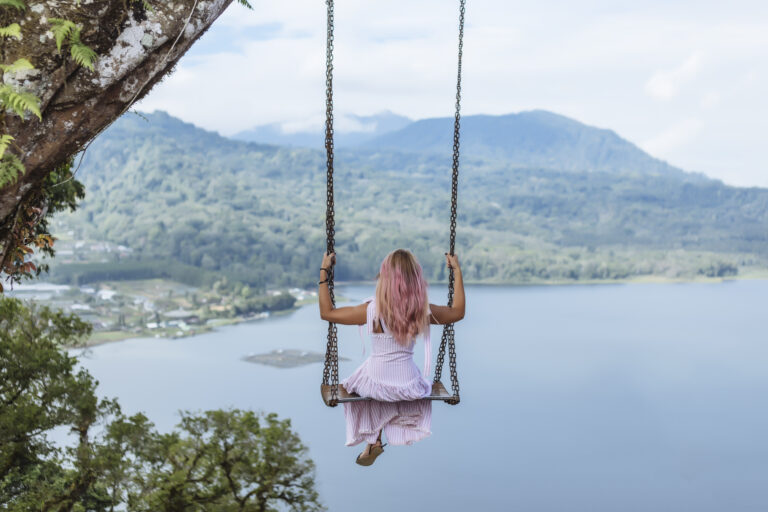 Indonesia, Bali, young woman sitting on swing