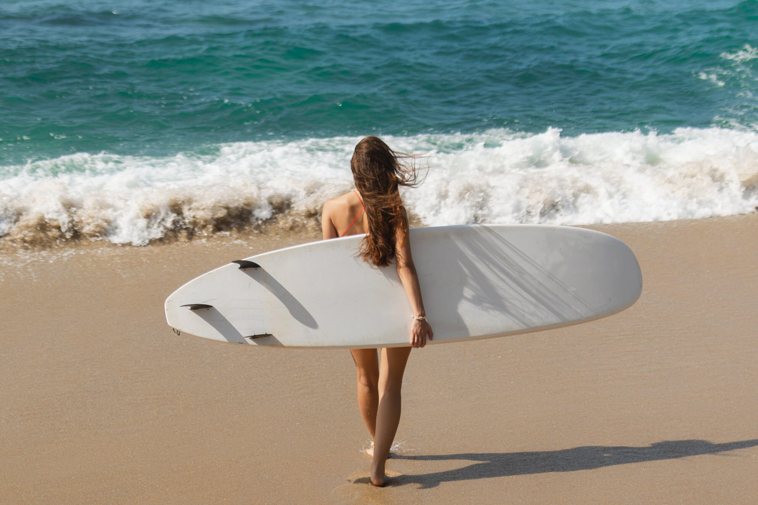 Walking Surfer Woman with Surfboard on the Tropical Beach