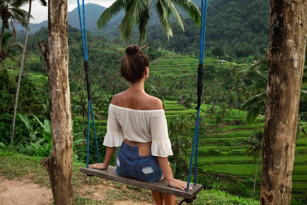 Woman on rope swings with beautiful view on rice terraces in the