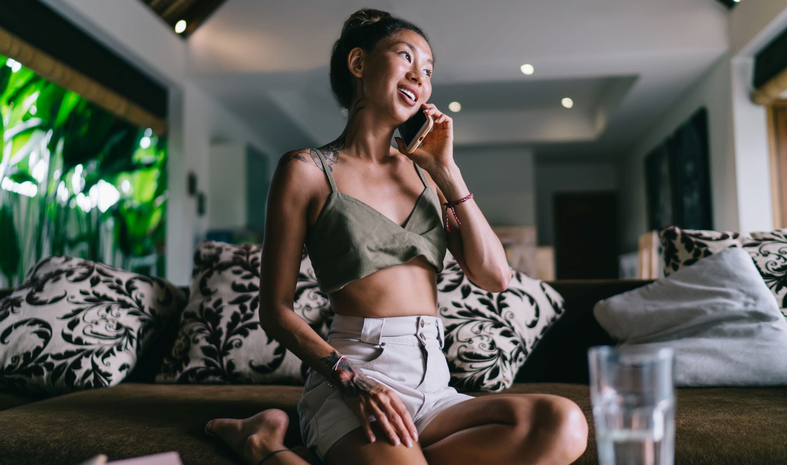 Young cheerful female in casual summer wear talking on phone