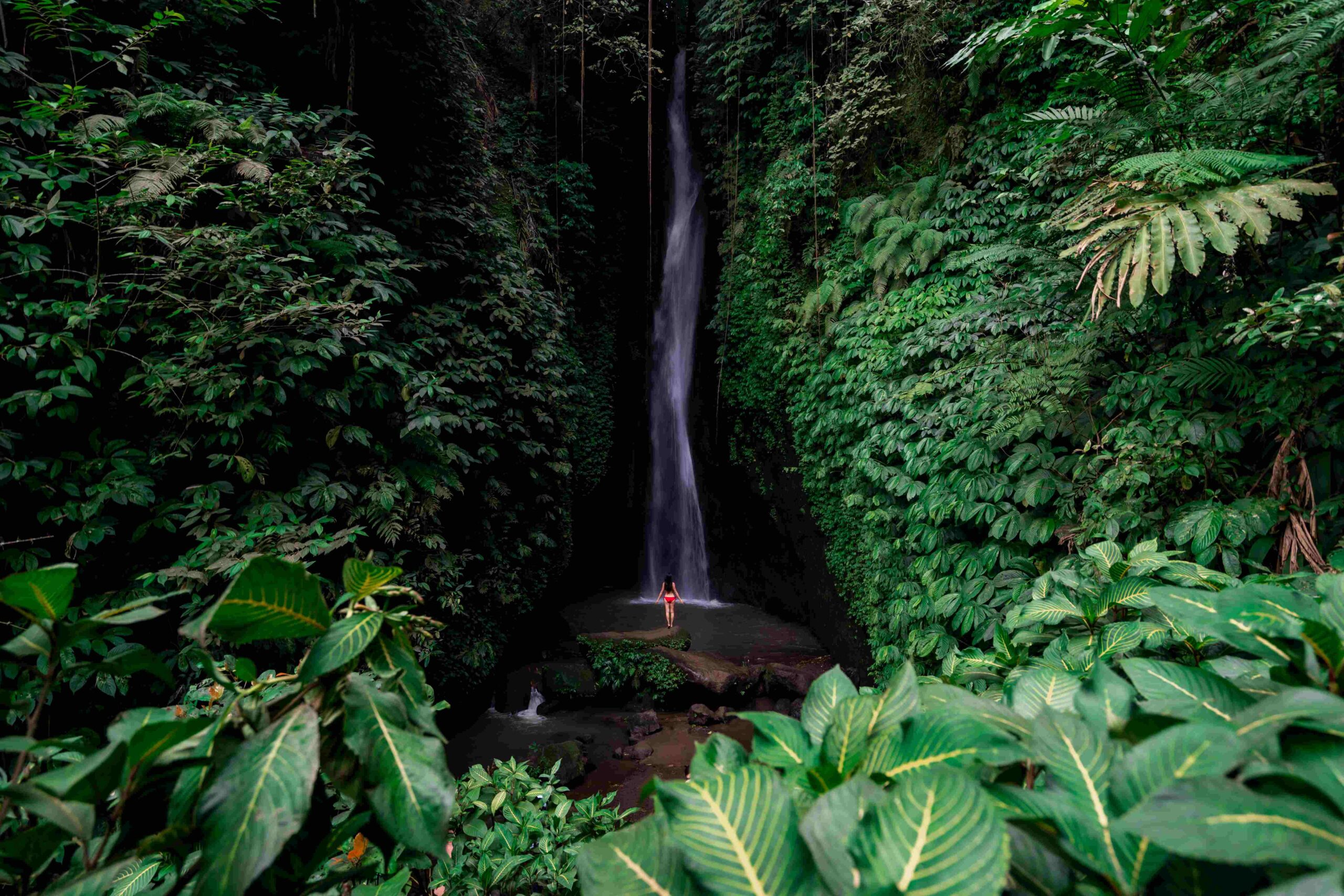 Young female tourism enjoying the Leke Leke waterfall at Bali in Indonesia