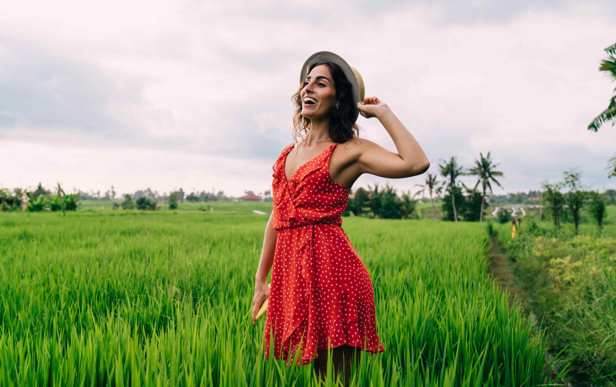 Young lady in high grass on cloudy weather