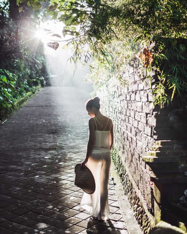 Young slim asian woman walking in beautiful morning sun rays, am