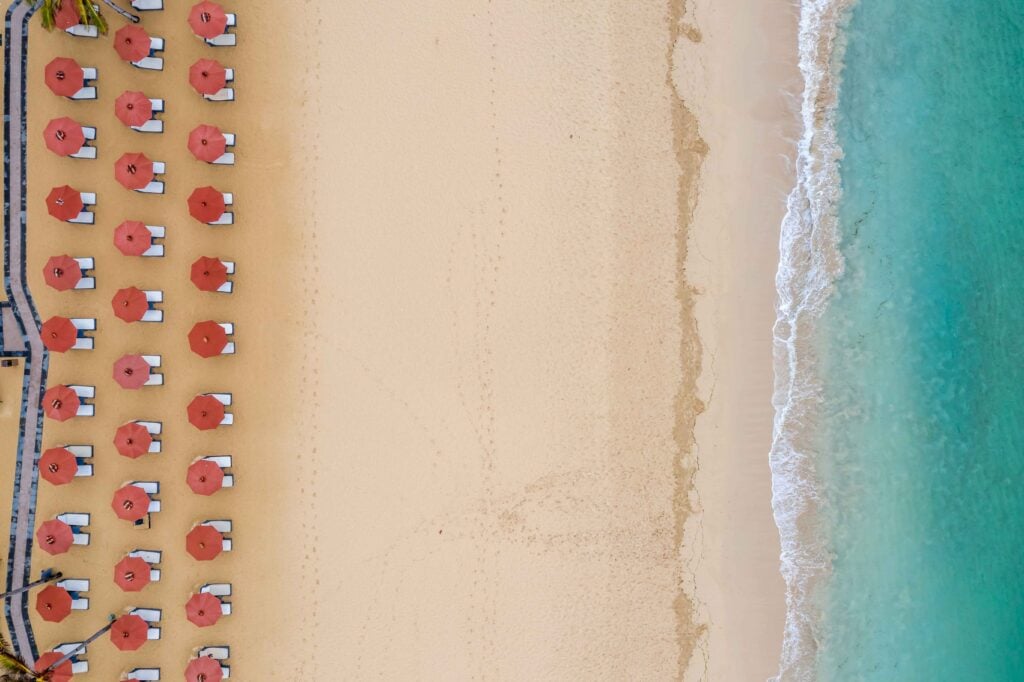 Aerial symmetric shot of beach umbrella rows at the Nusa Dua beach in Bali, Indonesia