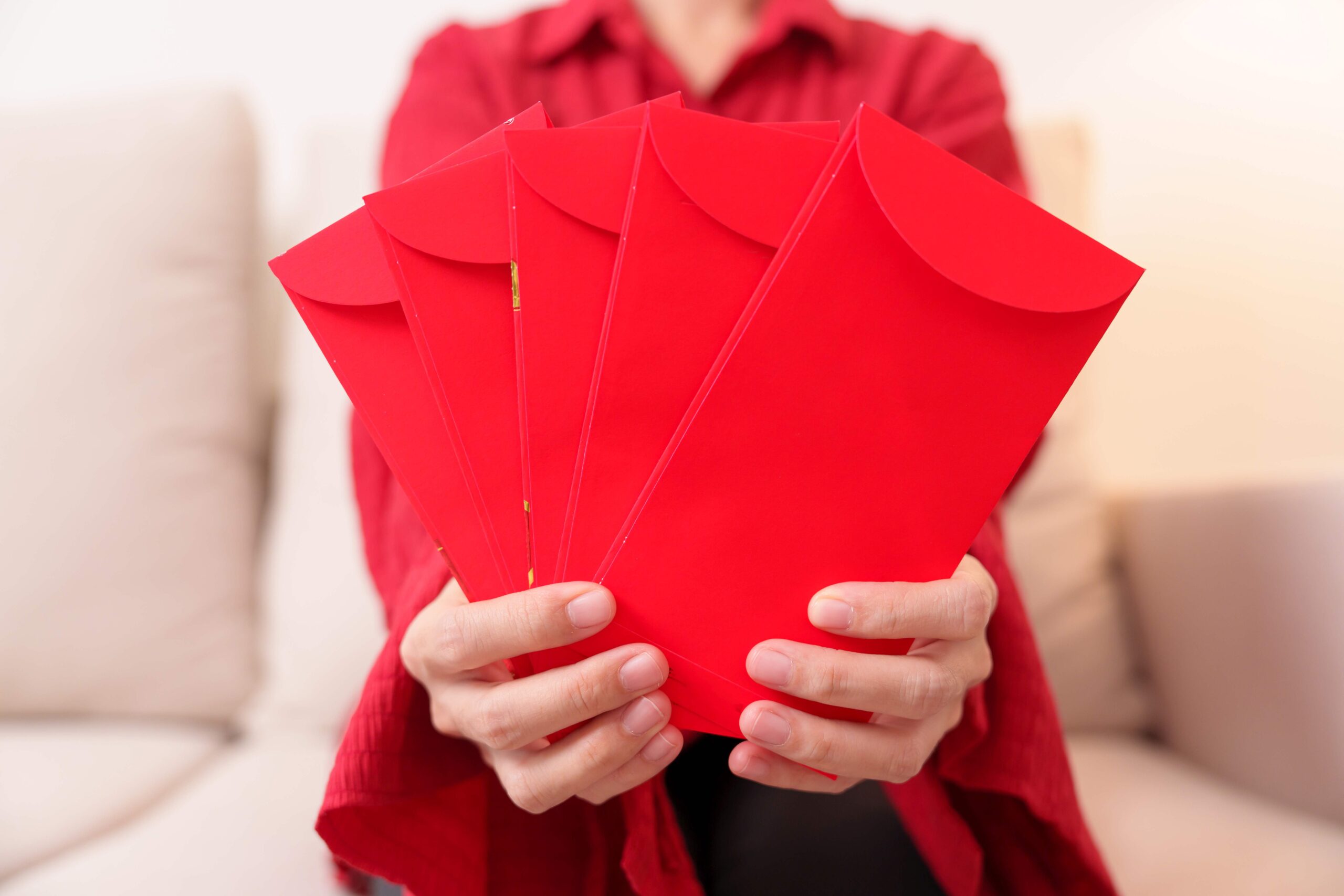Woman holding Chinese red envelope, money gift for happy Lunar N
