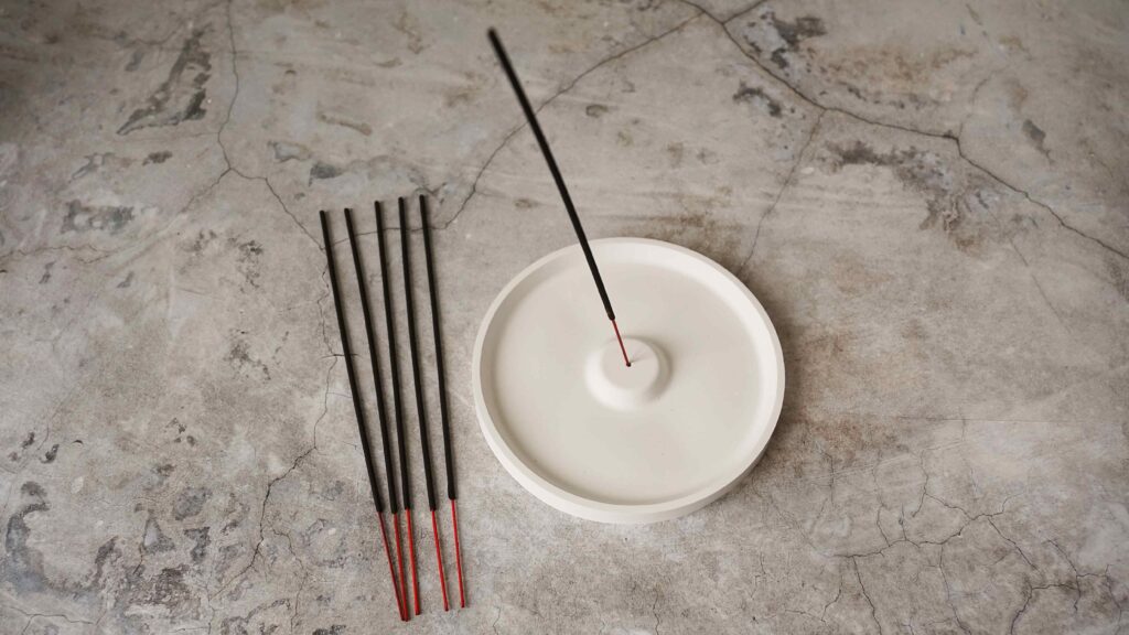 Incense stick in porcelain craft ceramic holder on marble table
