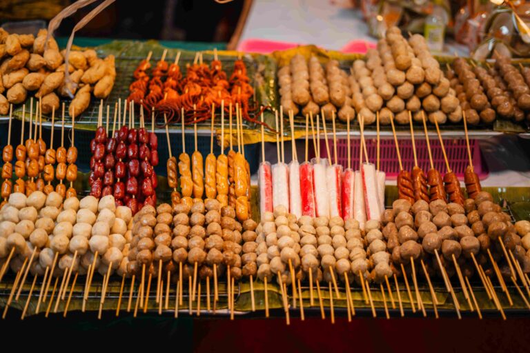 Skewers of streetfood on a table in Thailand,Steamed hot dogs