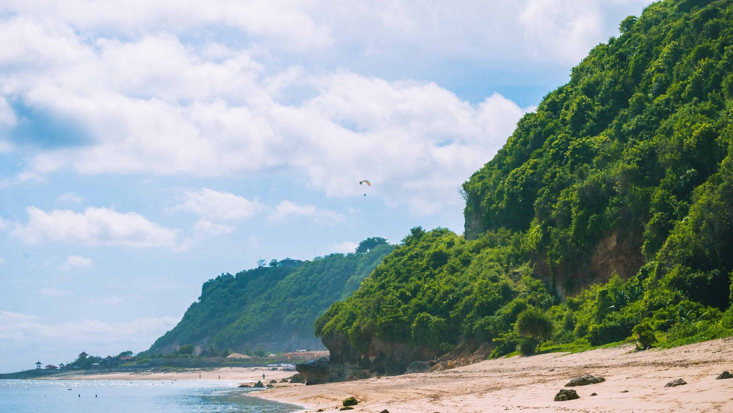 Paraglider flying above Pandawa beach, Bali island, Indonesia