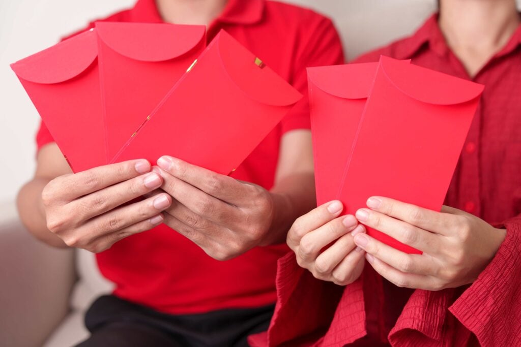 People hand giving Chinese red envelope, money gift for happy Lu