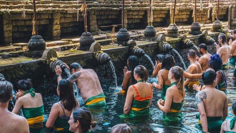 people bathing at pura tirta empul holy springs