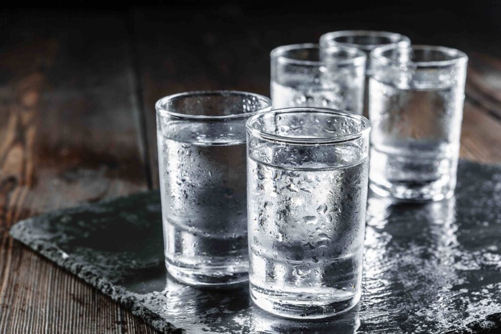 Vodka in shot glasses on rustic wood background