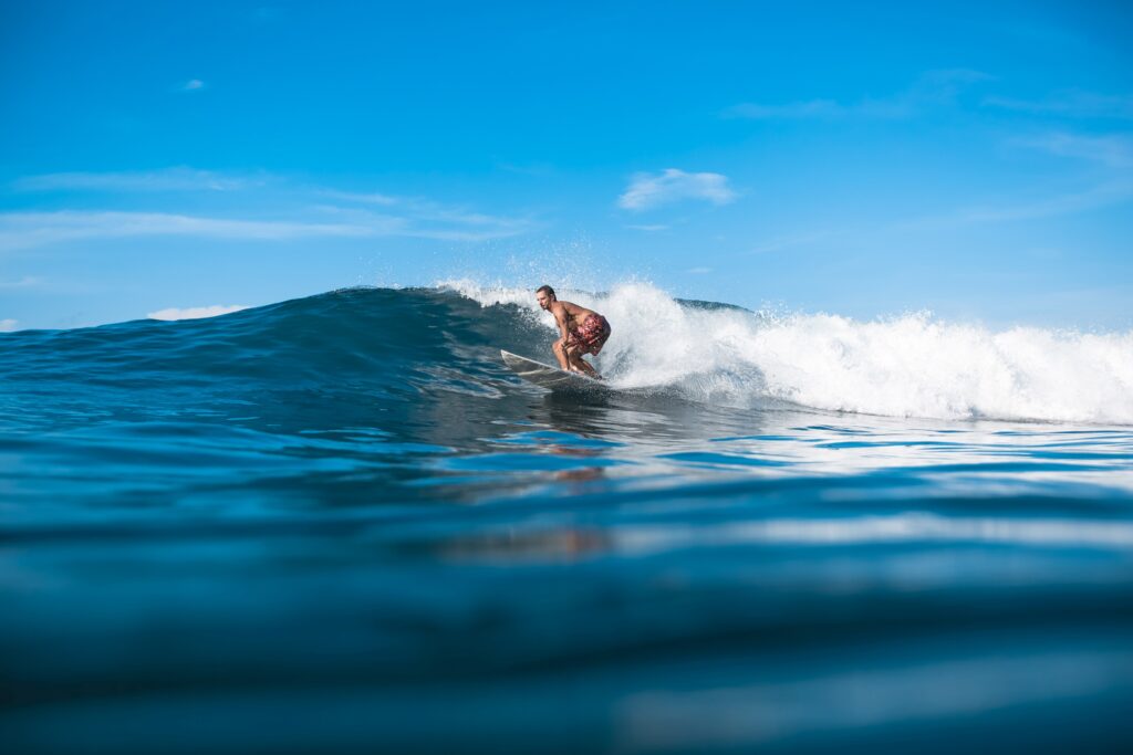 young sporty man having fun on surfboard on sunny day