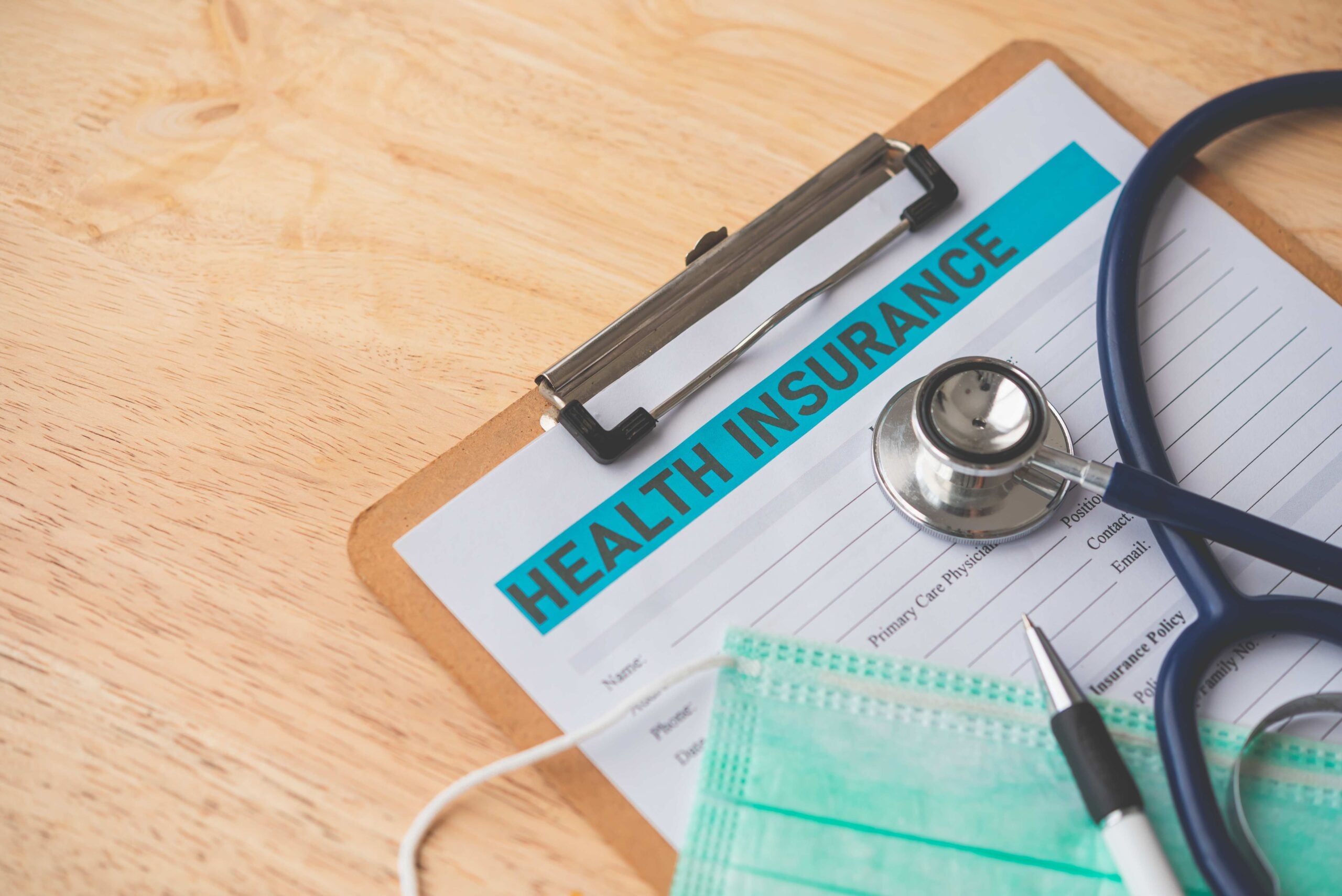 Stethoscope and calculator placed on health insurance documents,