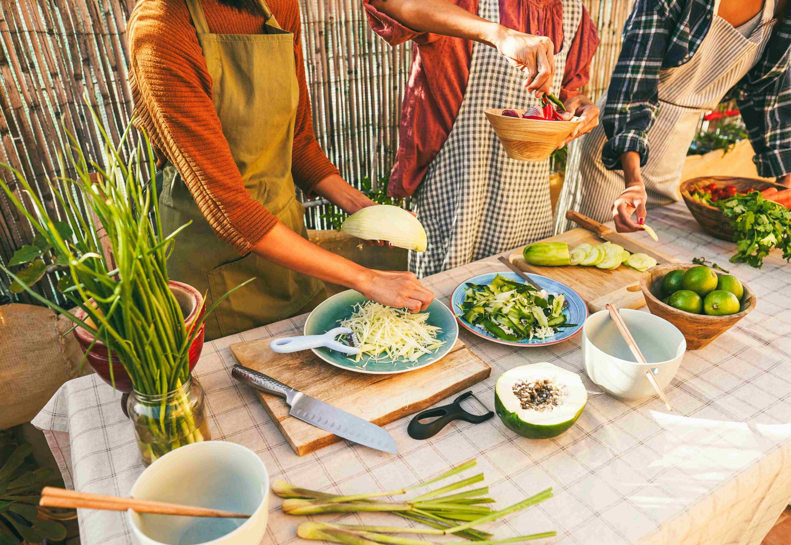 Asian family cooking thai dinner together while preparing papaya