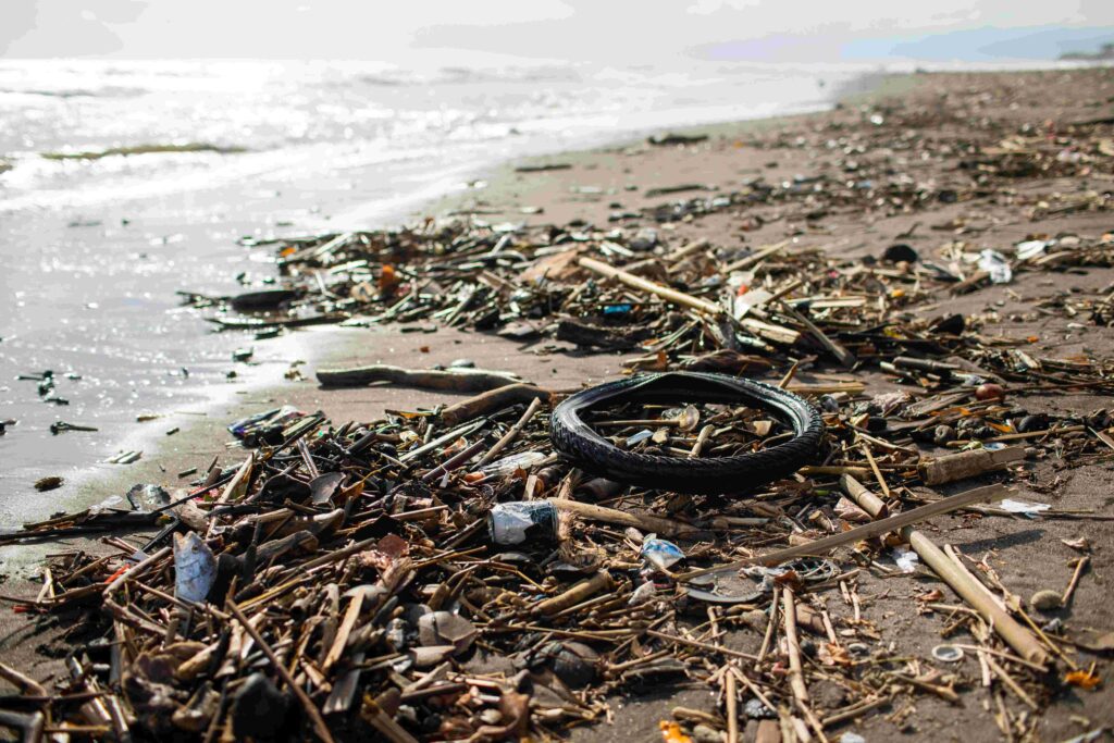 Beach pollution with plastic bottles, rubber tyre and other wast