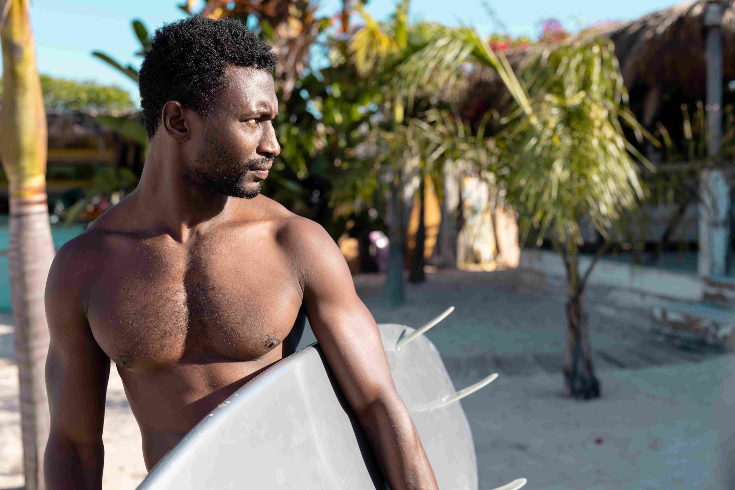 Happy african american man holding surfboard at beach Spending quality time, lifestyle, summertime and vacation concept