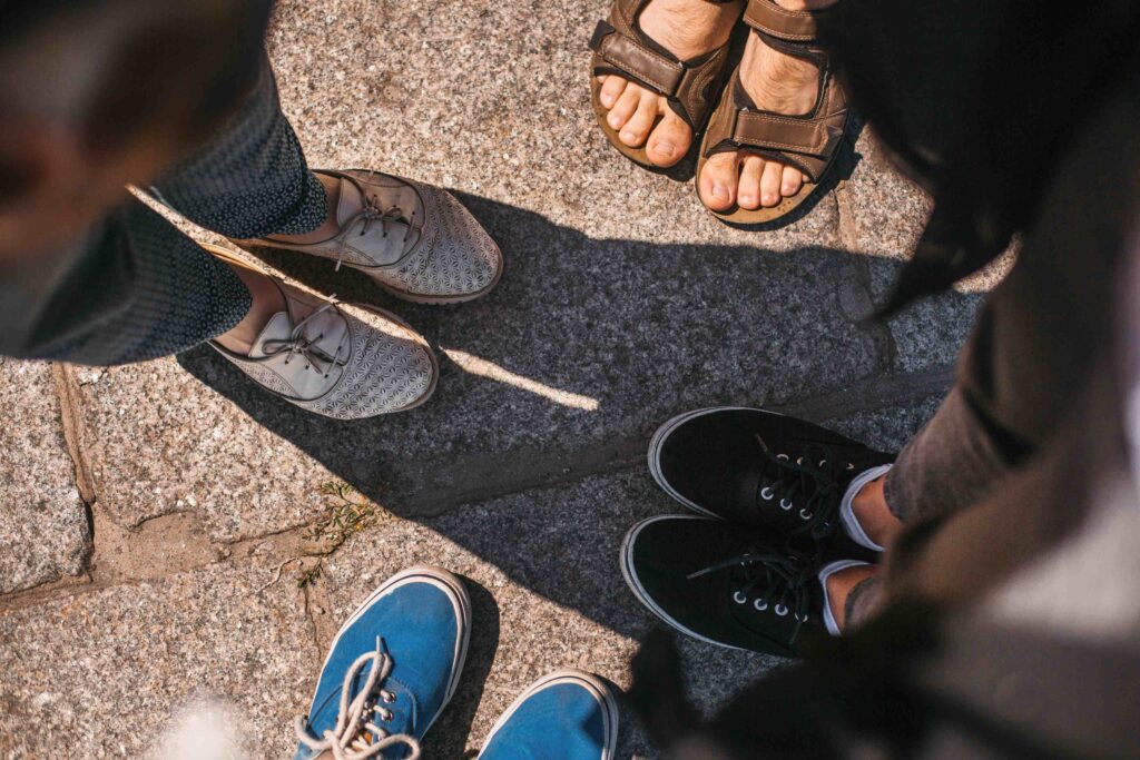 top view of friends shoes on road