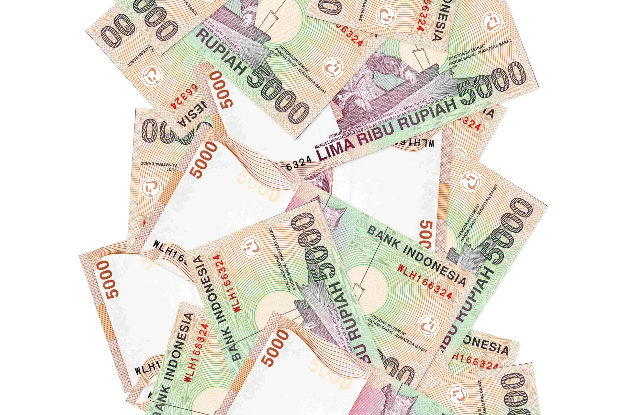 5000 Indonesian rupiah bills flying down isolated on white Many banknotes falling with white copyspace on left and right side