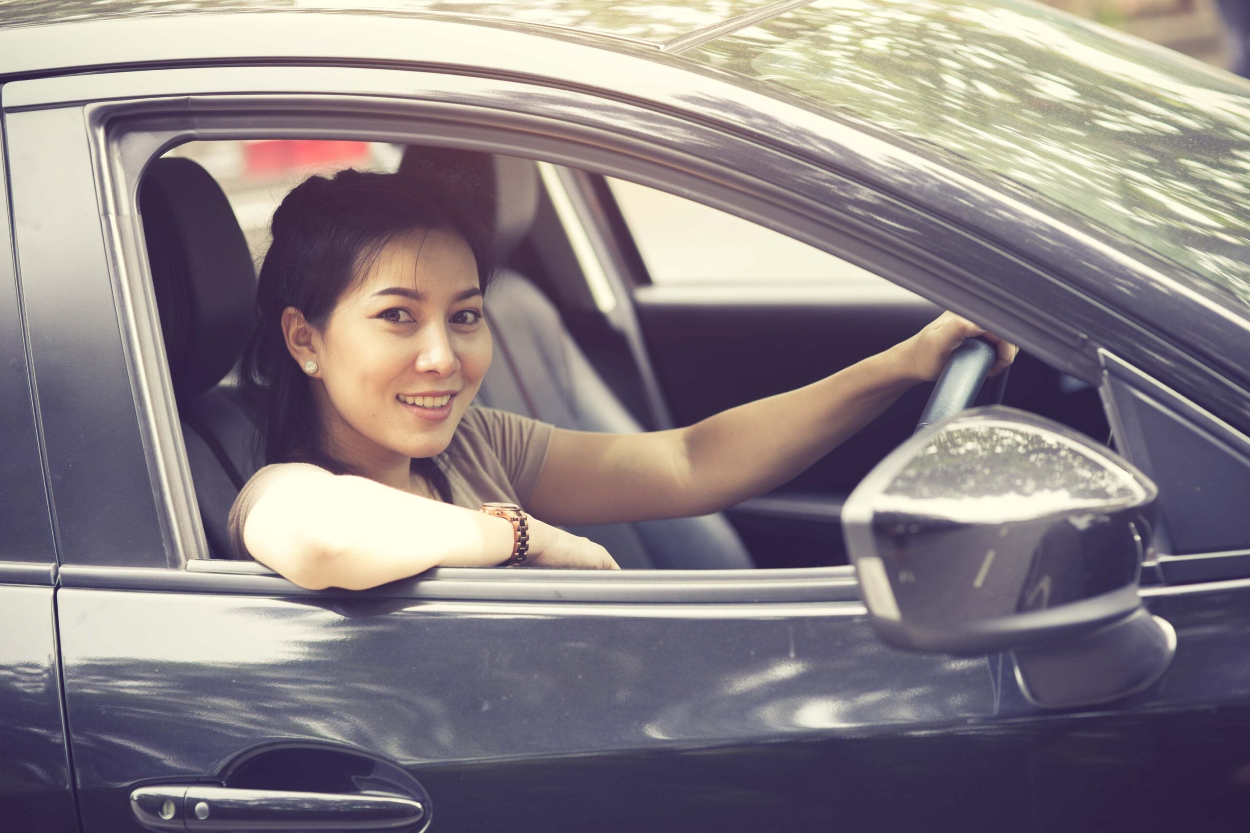 Beautiful girl is smiling while driving a car