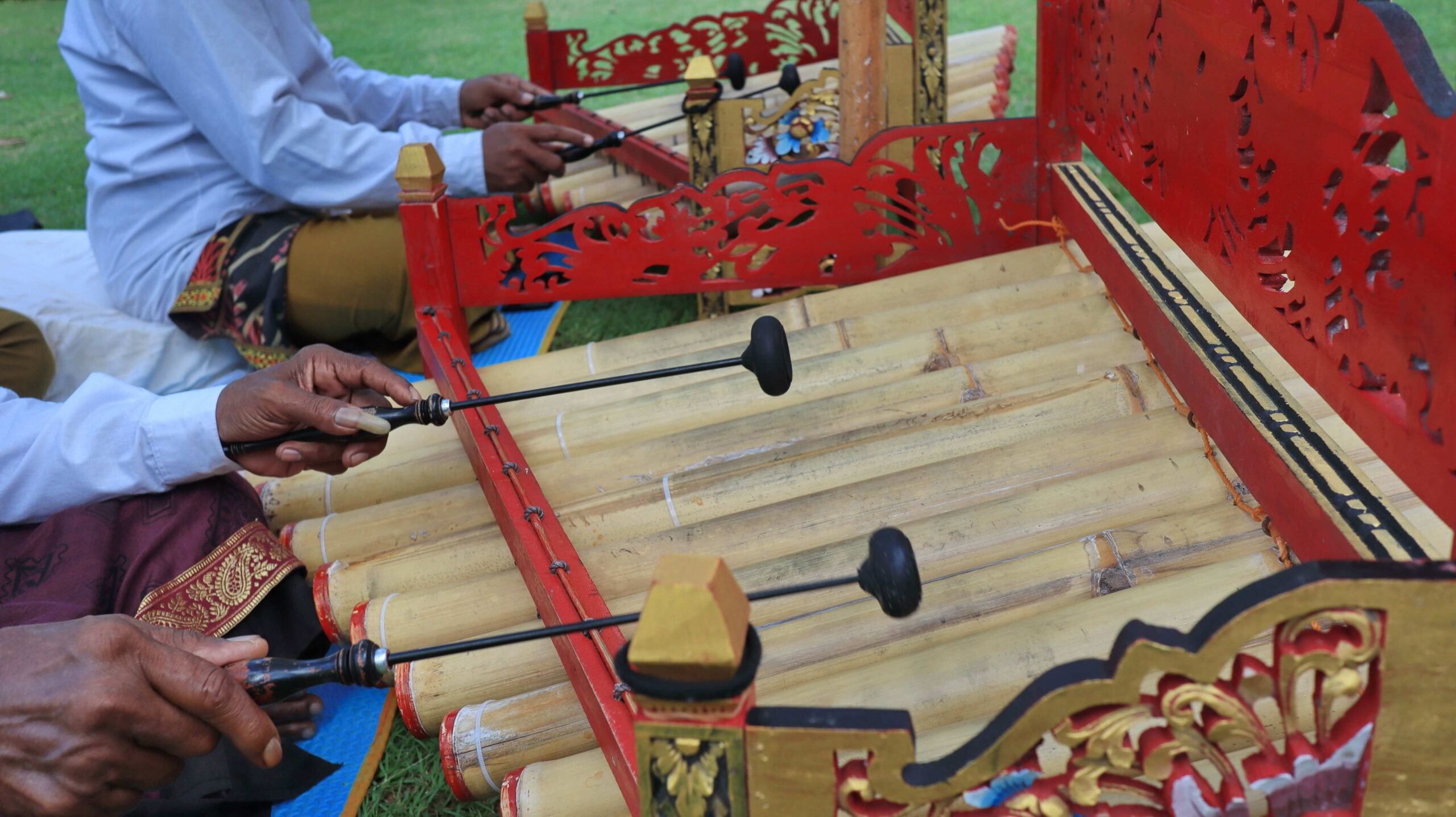 Group of musicians performing on traditional Balinese Rindik instruments in a public park