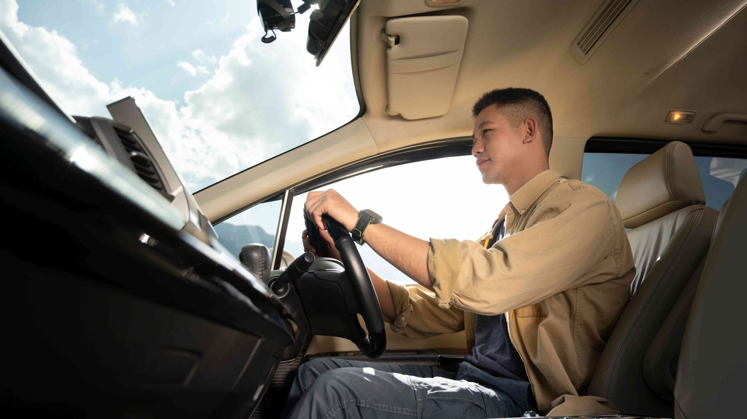 Handsome man driving car enjoying road trip on vacation Transport, summer vacation and holiday
