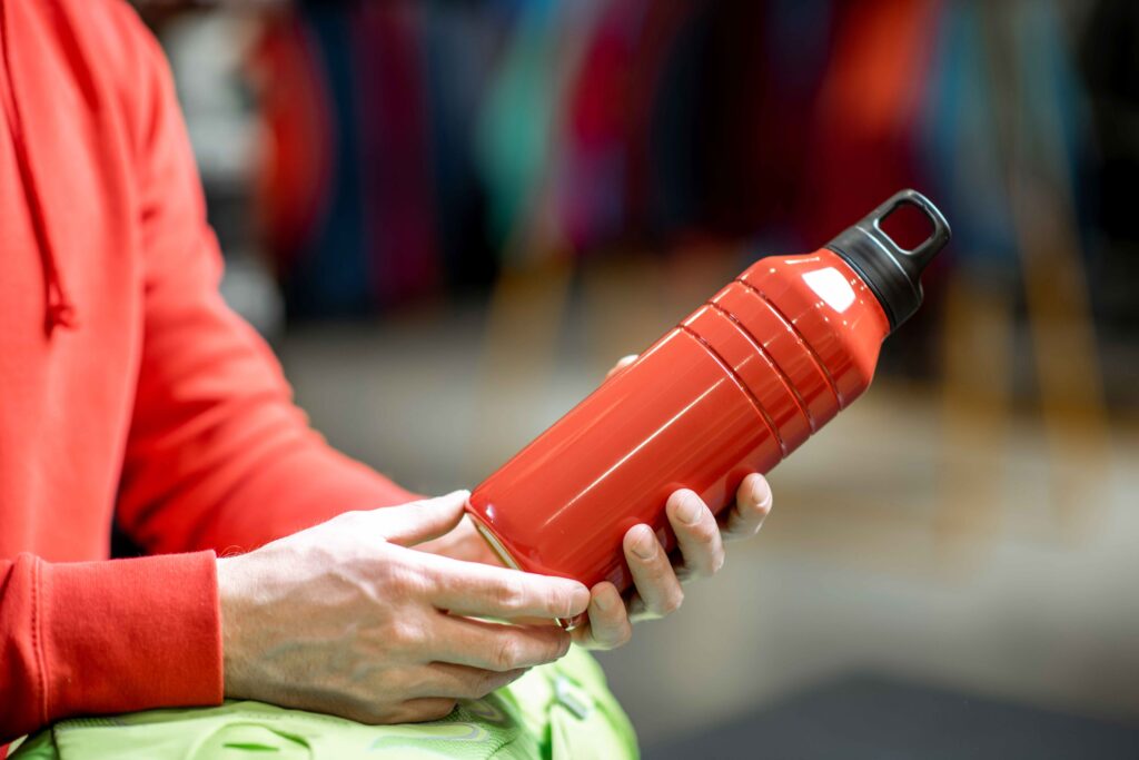 Holding red thermos for hiking