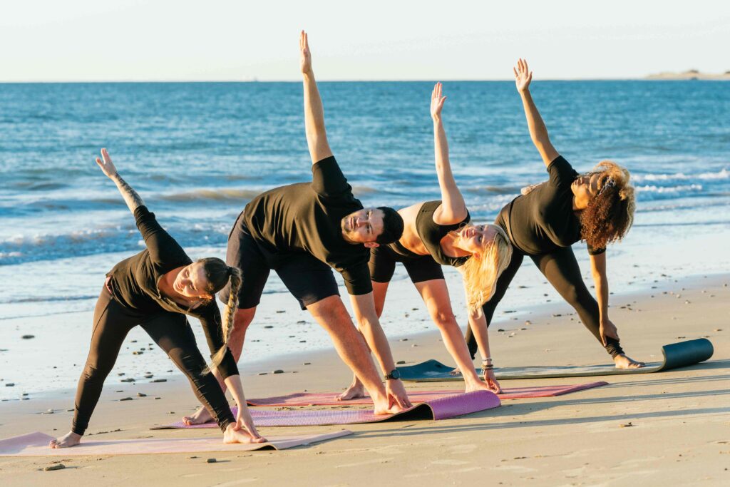 Multiethnic yoga group doing a class on the beach