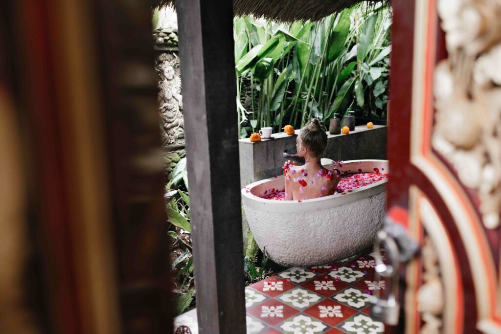 Pleasant woman sitting in bath in room with luxury interior Indoor photo of adorable girl doing sp