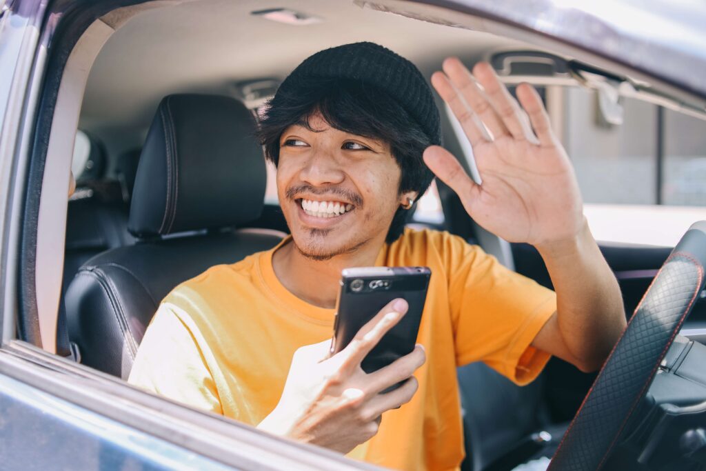 smiling online taxi driver holds smartphone and wa 2023 11 27 04 57 05 utc