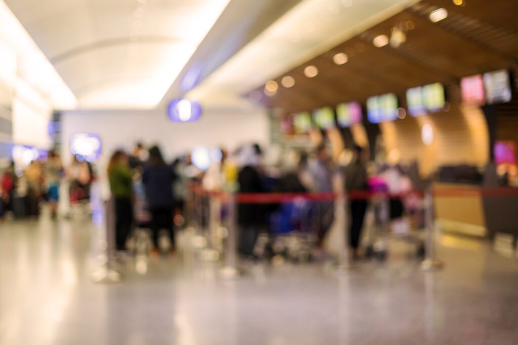 Blurred image of passengers wait in a queue for check in in the airport