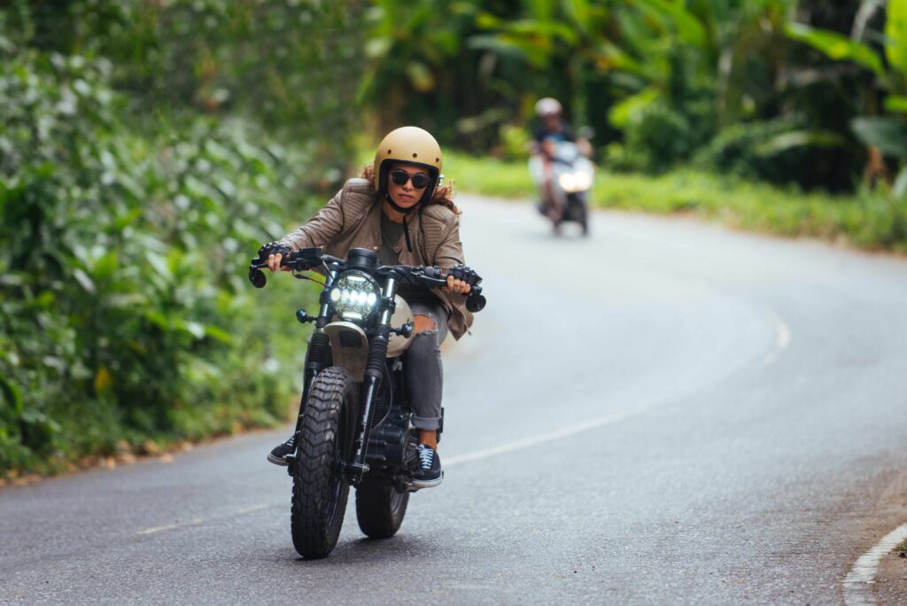 Female biker driving a cafe' racer motorbike